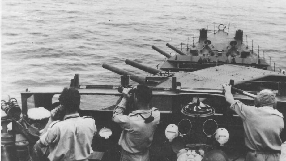 TAKING AIM: Arunta crewmen aim the ship's guns during a bombardment. Photo: Royal Australian Navy.