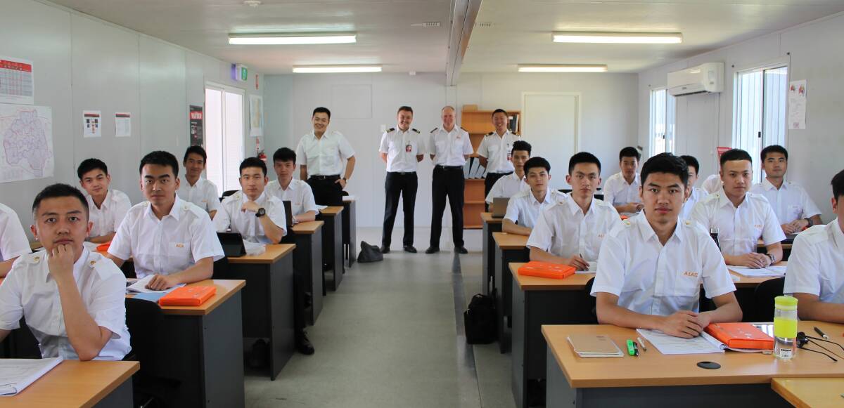 New school: AIAC's chief flying instructor Kevin McMurtrie and flight instructors Steven Detheridge and Ben Li (back) with students at the Kempsey flying school.