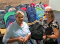 Walcha Rotary Club member, Lois with Maria Showell of Pathfinders with the backpacks donated for children in foster care. Picture supplied. 