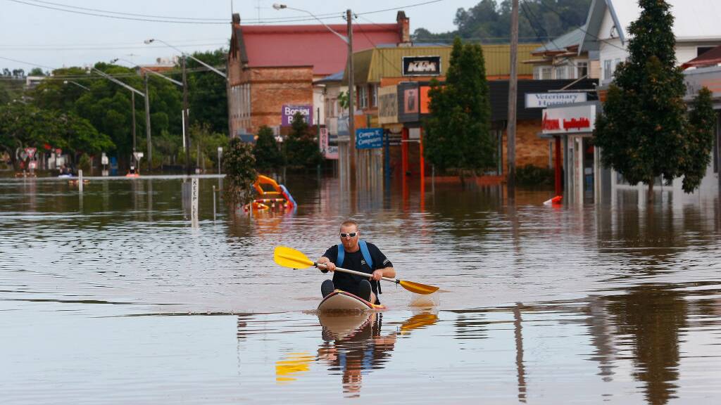 A man paddles a kayak down a street on April 1, 2017 in Lismore. Photo: Jason O'Brien/Getty Images