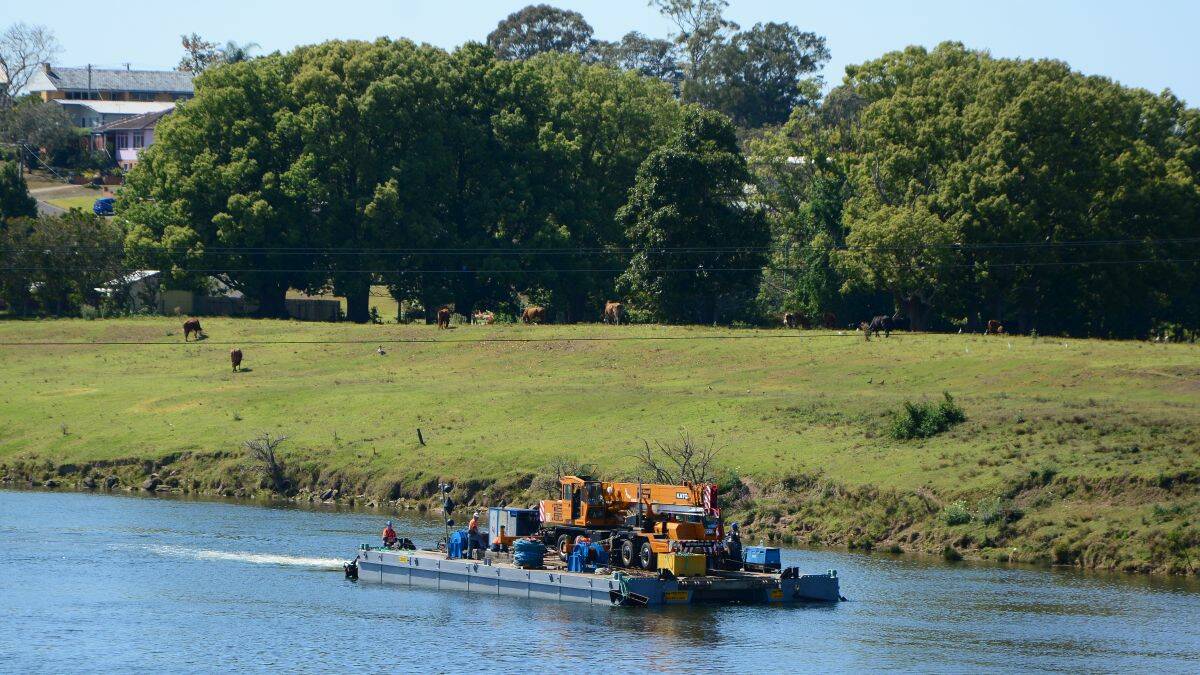 The barge carrying a crane makes its way up-river to the railway bridge.