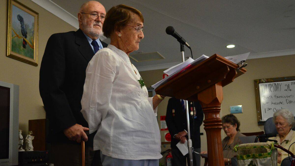 Honouring the fallen: resident Dot Robinson, flanked by Kempsey-Macleay RSL Sub-branch member Ken Hills, reads a prayer.