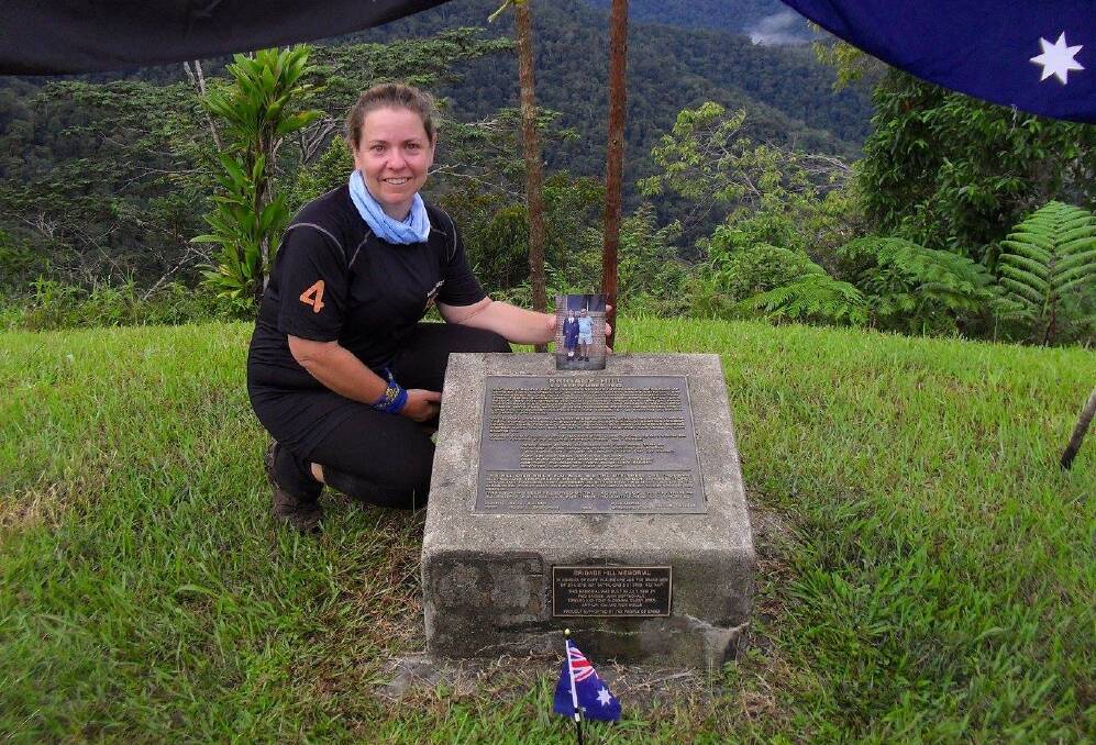 Rachel Kerrigan with a photo of her and her grandfather Garvin Townsend at the Brigade Hill memorial on the Kokoda Track earlier this month 