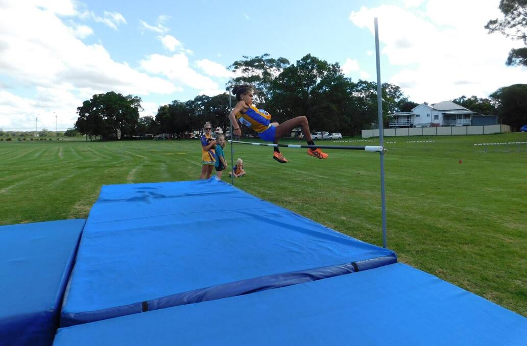 Jump: A Kempsey Little Athletics members leaps over the bar in the high jump event. Photo: Supplied.