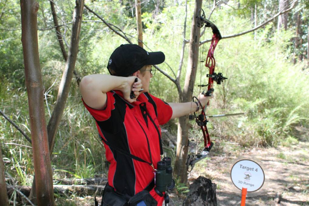 A club archer takes aim with her compound bow.