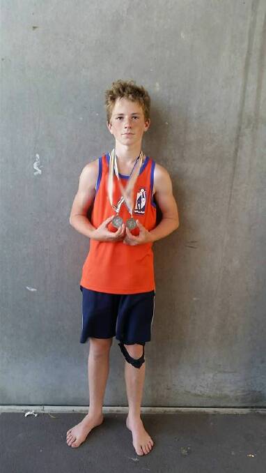 NCIS champion: Kempsey Adventist School’s Carson Hudson with his winning long jump and high jump medals. Photo: Supplied.