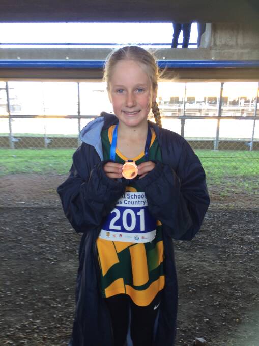 Cleo Schubert proudly holds her bronze medal she won for finishing third at the NSW All Schools Cross Country State Final last Friday.