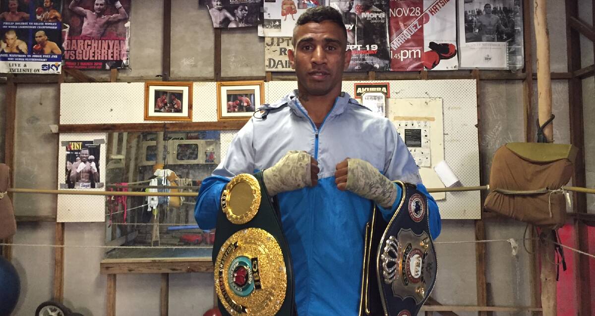 Champion: Renold Quinlan holds up his PABA Super Middleweight and TBO International title belts in his training ring at Kempsey, ahead of his fight against Daniel Geale.