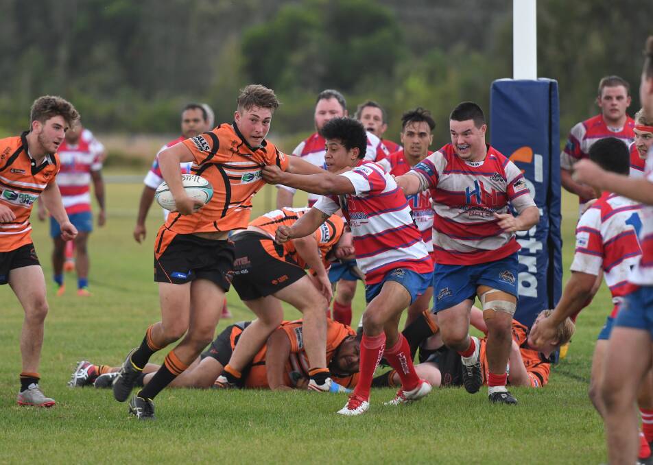 Stiff arm: Cannonballs first grade flanker Jeremy Winn palms off a Wauchope Thunder defender in their victory on Saturday. Photo: Penny Tamblyn.