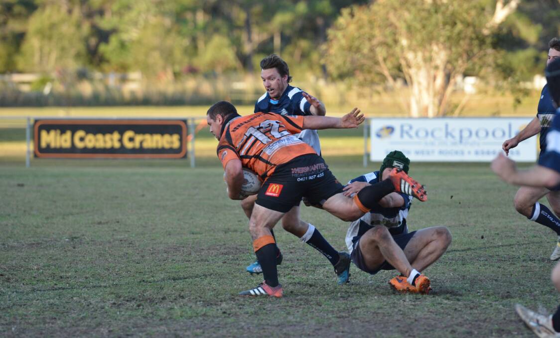 Hard running: Kempsey Cannonballs first grade player Braden Farrawell brushes off a SCU Marlins defender in Saturday's 29-24 loss on home soil. Photo: Penny Tamblyn.