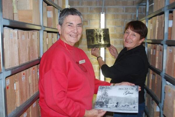 Hidden treasures: Macleay River Historical Society volunteers Judy Waters and Debbie Reynolds in the specially-constructed storeroom housing the Angus McNeil slides. Each box contains around 100 slides and each of the shelf cubicles contains six boxes.