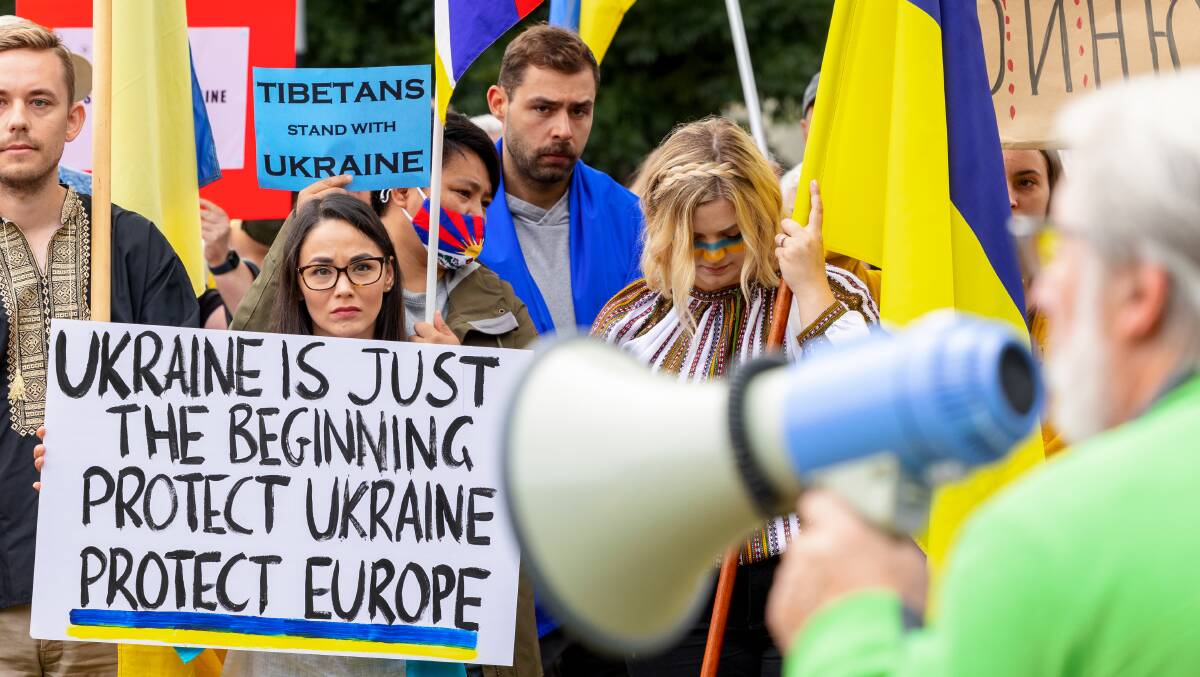 A protester holds a sign warning Europe could suffer if Ukraine is occupied by Russia. Picture: Sitthixay Ditthavong