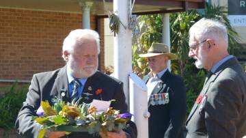 Kempsey Macleay RSL sub-Branch president Allan Wardrope carries a wreath.