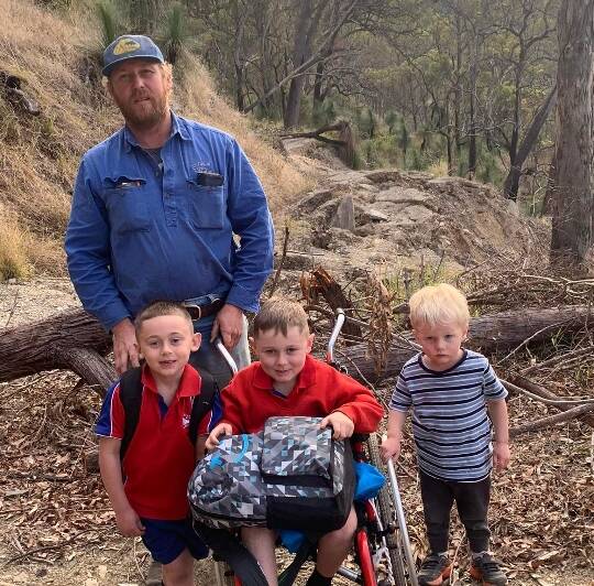 Newman Hollis with his sons (L-R) Theo, Reid and Charlie on the school "carry". When Reid recently broke his leg, he had to be airlifted out for medical attention. Photo: supplied
