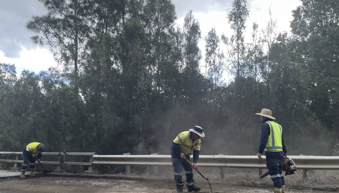 Workers on South West Rocks bridge that crosses Spencers Creek work with a fresh layer of asphalt while rain holds off. Picture by Ellie Chamberlain