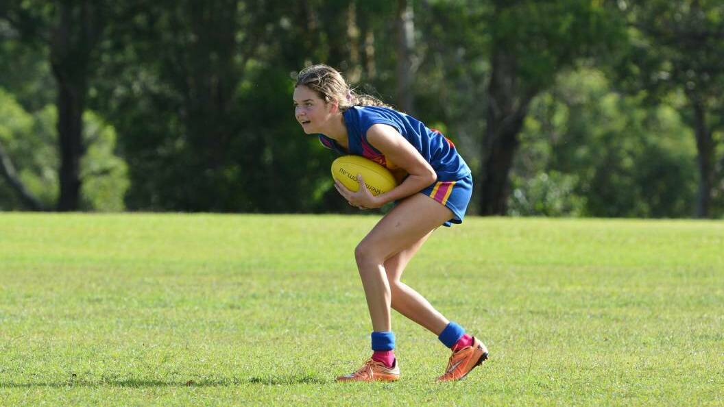 VISION UPFIELD: A Macleay Valley Eagles youth girl with the sherrin in hand earlier this year. AFL is growing in popularity on the Mid North Coast and across NSW.