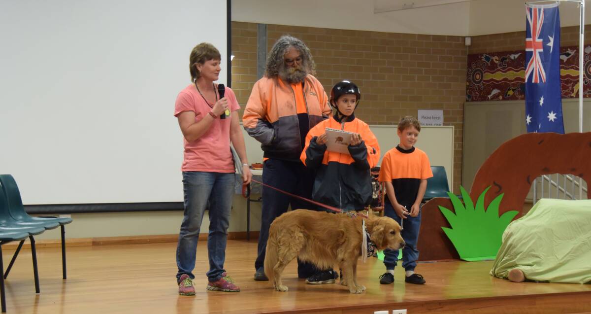 SAVING DOGS: Children's book author Lisa Domeny of Team Golden Oldies, Sam the golden retriever, Eric Natty, Byron Natty and Eric Natty, on stage at South West Rocks Public School for Book Week 2017.