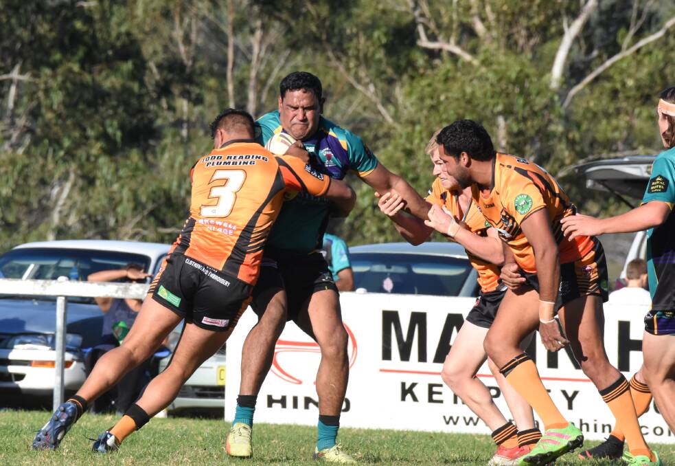 Taree City second rower Michael Peachey is wrapped up by Wingham centre Lonny Clarke during the clash at Wingham. Taree City won 30-16.