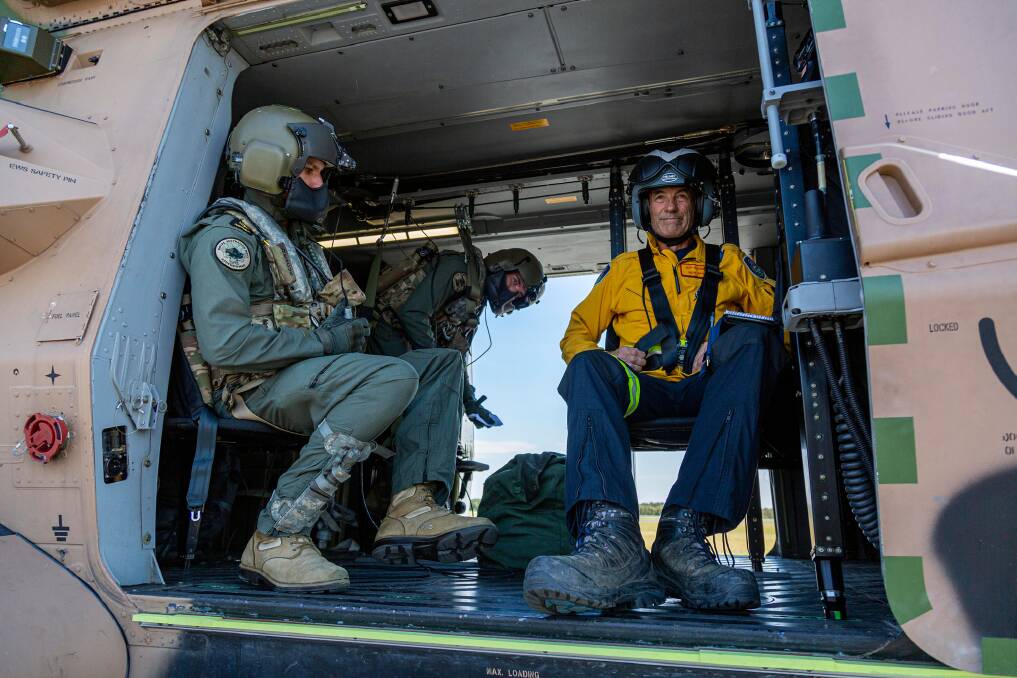 Leading Seaman Aircrewman Benjamin Nixon (left) Petty Officer Aircrewman Damien Wallace (centre) and Rural Fire Service volunteer Jeff Hodder (right) prepare to leave Royal Australian Air Force Base Williamtown, Newcastle, onboard a Royal Australian Navy MRH-90 Taipan Multi-Role Helicopter, to support the firefighting efforts in New South Wales