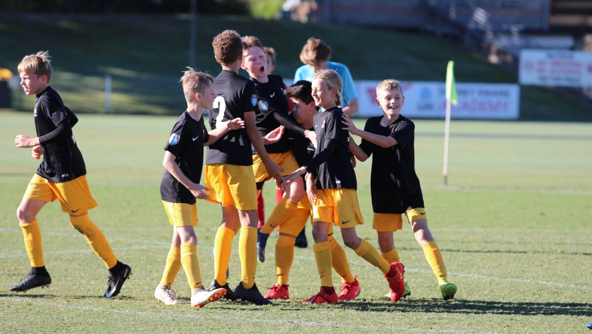 On their way: Mid North Coast celebrate a goal in their 3-0 win in the state final at Coffs Harbour. Photo: Taylah Curran/Northern NSW Football.