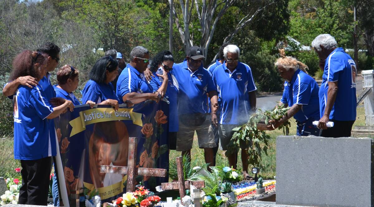 SPIRITUAL GUIDANCE: Lewis 'Buddy' Kelly's siblings gather around his grave during the smoking ceremony. Photo:Vanessa Arundale