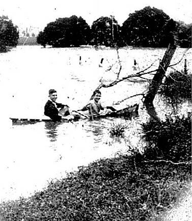 Merv Lynch and friend crossing the flood waters in canoe - the bridge posts are just visible in the background.