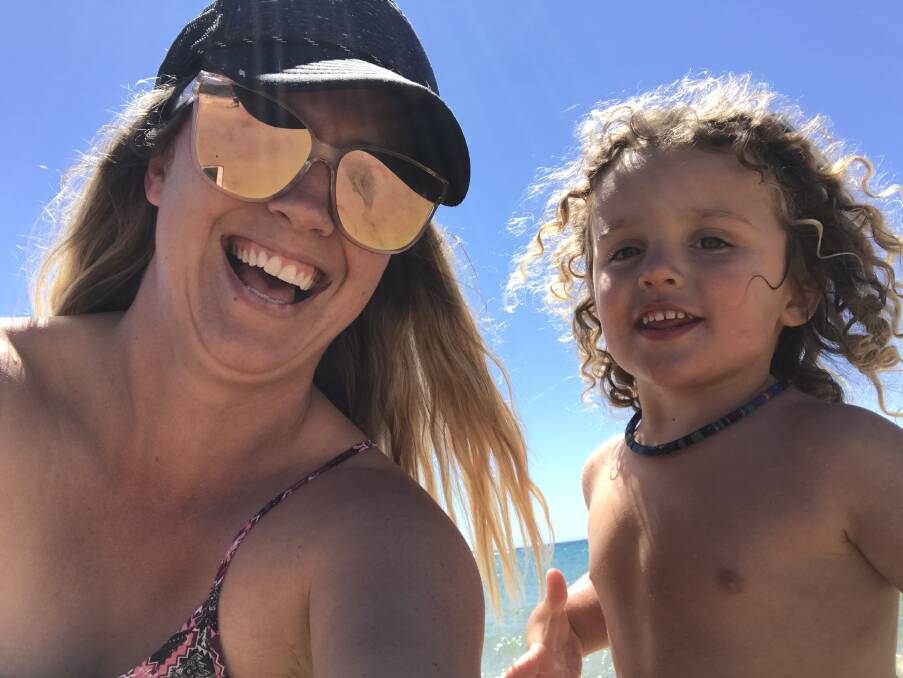 Beach boy: Nicole Fuller, with Vinnie, at the beach. Vinnie had been playing happily at the beach in the days before he was flown to Newcastle for treatment