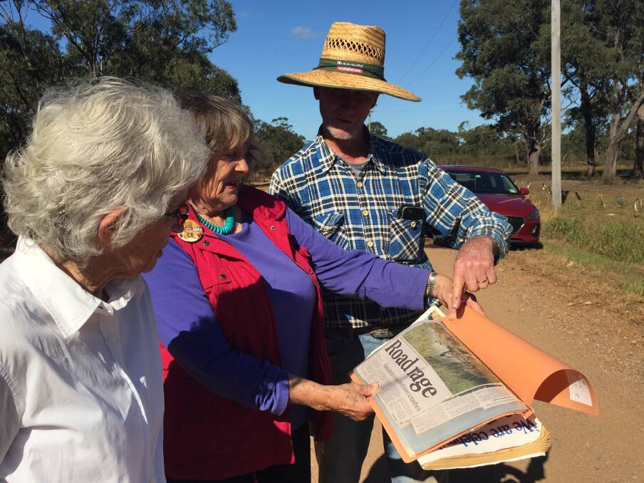 LONG BATTLE: Beverley Dick, Narelle Milligan and Denis Chard look at some of the past coverage of the Maria River Road issue. 