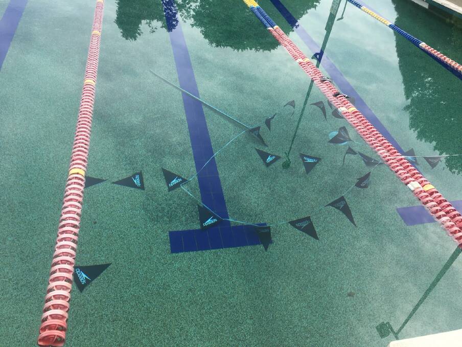 Flags lying at the bottom of the pool after the poles were snapped off