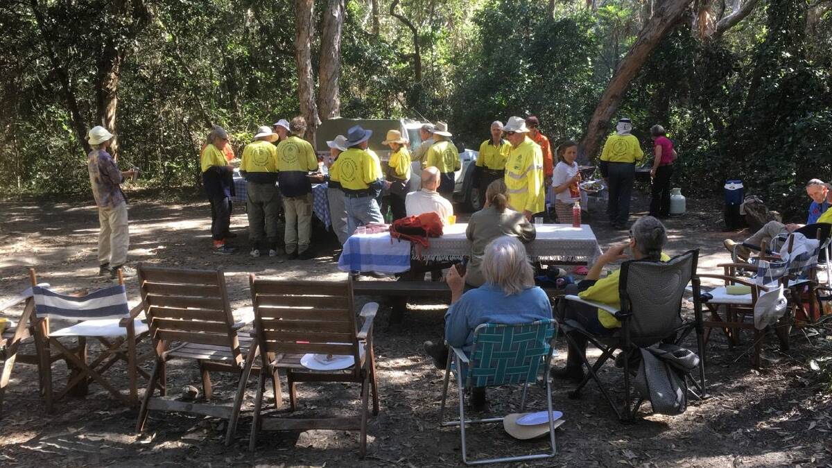 Forty SWR Community Dune Care volunteers tuck into lunch after weeding bitou bush at Smoky Beach in August.