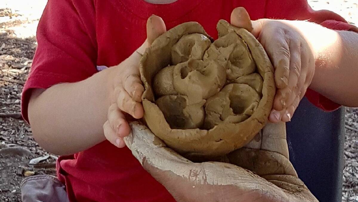 COMMUNITY ART: The children have been learning the story in language, while enjoying moulding the clay into nests and eggs together with their families. Photo supplied.