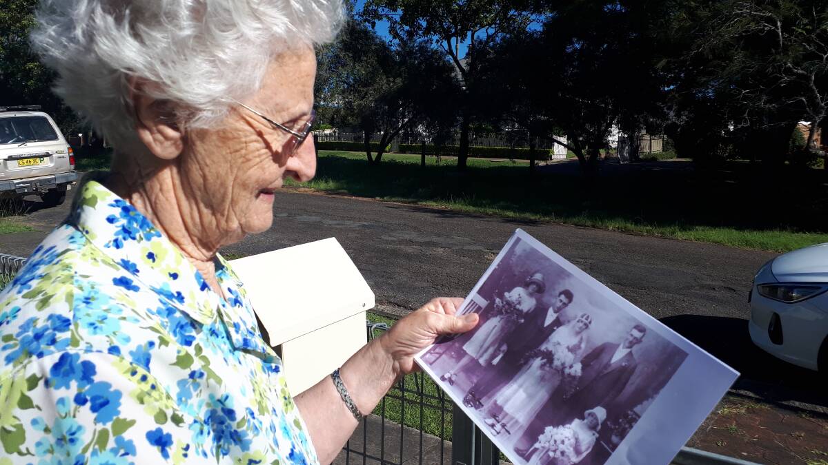 Nessie Brown Henry holding a wedding photo of her parents and helping identify the bridal party. The Kempsey Museum desperately needs "the memory" of the older members of the Macleay Valley community to "put names to the faces". Photo supplied. 