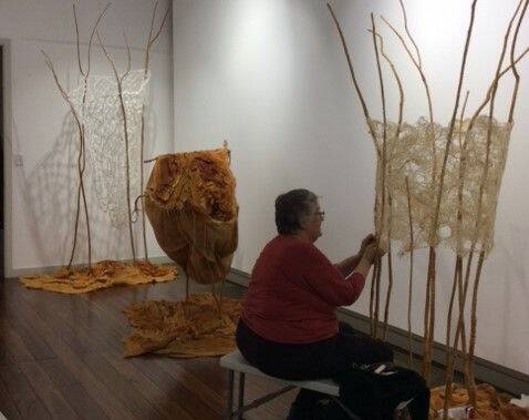 One of the exhibtion's Taree fibre artists working on exhibition installation. Photo supplied.