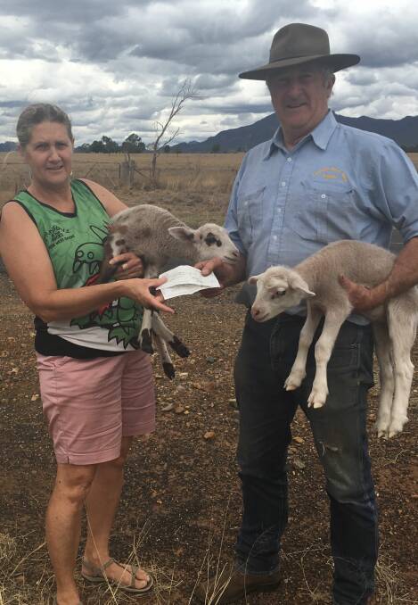 HELPING HANDS: Jeannine Douglas president of Dragons On The Rocks hands over cheques to Bruce Henley owner of Baradine Rural Suplies, who will distribute the donations to farmers in the drought-stricken area of Baradine.