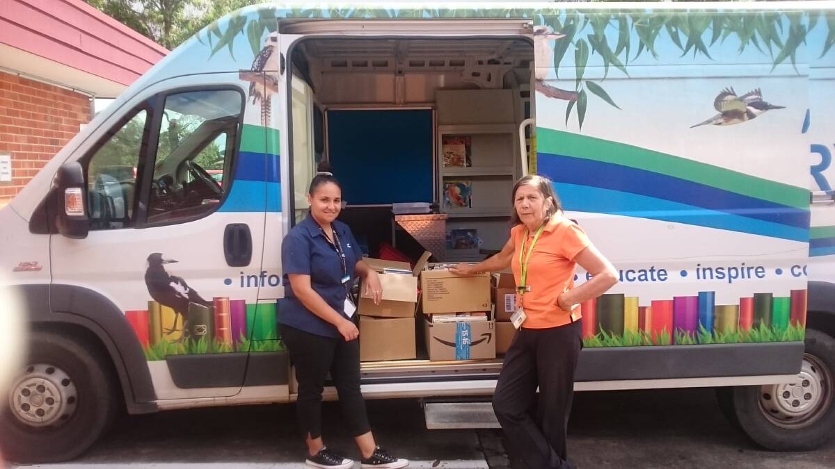 BOOKS ON WHEELS: Kempsey Shire Library staff members Ruth and Khatia setting off to deliver books.