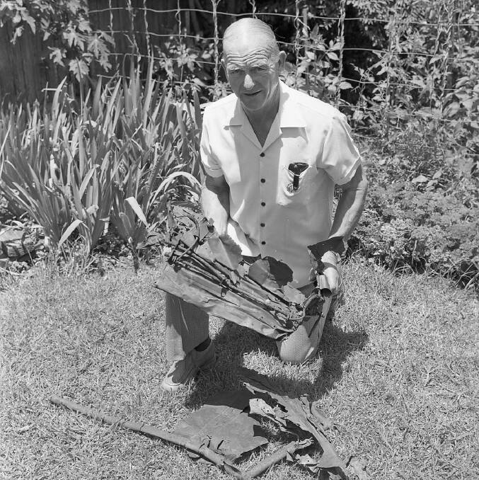 SEARCH: George Baxter formerly of Kempsey Police with parts of the crashed Kittyhawk in 1960. Photo: Macleay Argus archives.