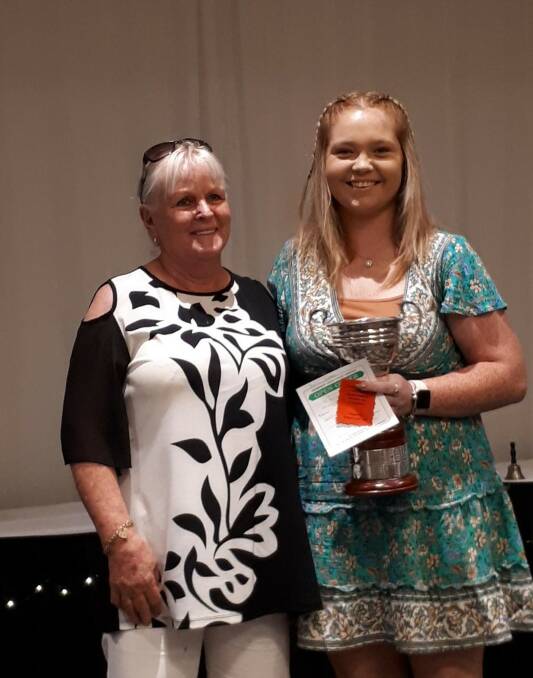 Outgoing champion Pam Bruce presenting Maddie Butterfield with her trophy.