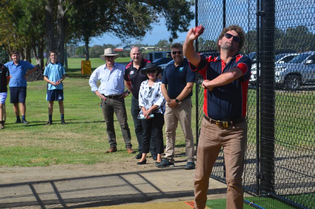 Macleay Valley Cricket Association President Carlos Peters rolls the arm over as members of council, Cricket NSW and local cricketers watch on. Photo: Lachlan Harper 