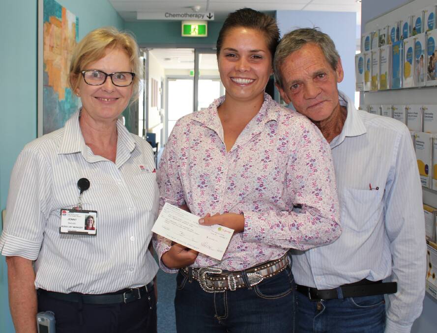 Neal Kyle and his daughter Merinda present $10,500, raised by the upper Macleay community, to Mid North Coast Cancer Institute Nursing Unit Manager Jenny Baroutis.