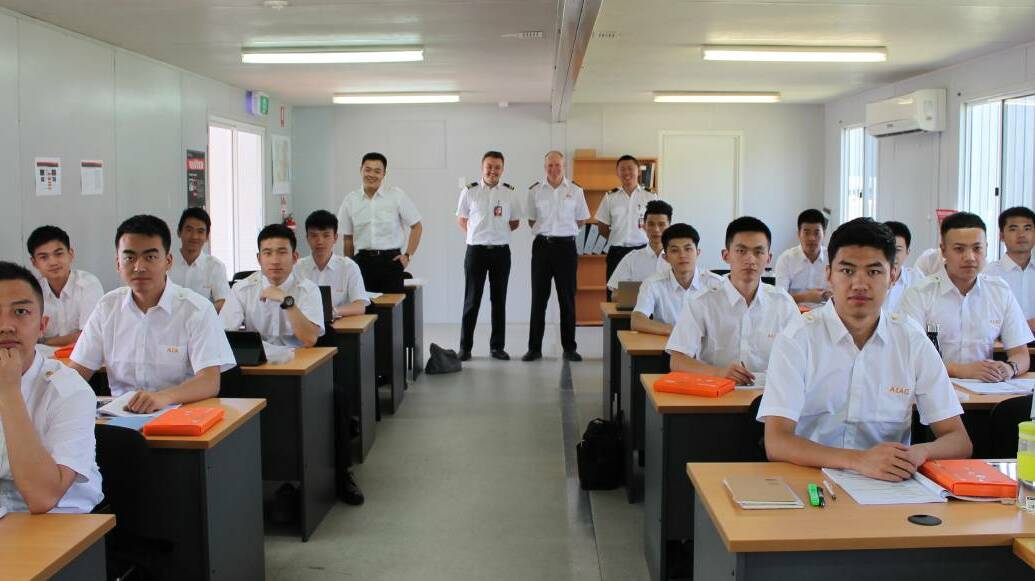 AIAC's chief flying instructor Kevin McMurtrie and flight instructors Steven Detheridge and Ben Li (back) with students at the Kempsey flying school.