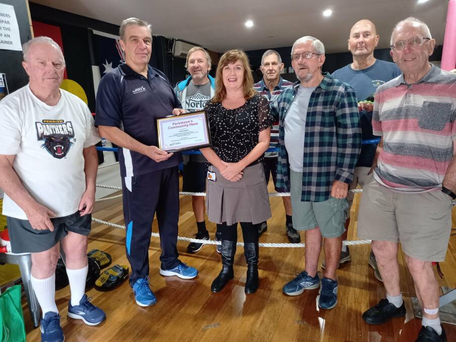 Boxing coach Dean Groth receives his Parkinson's Community Hero honour from members of the Port Macquarie support group