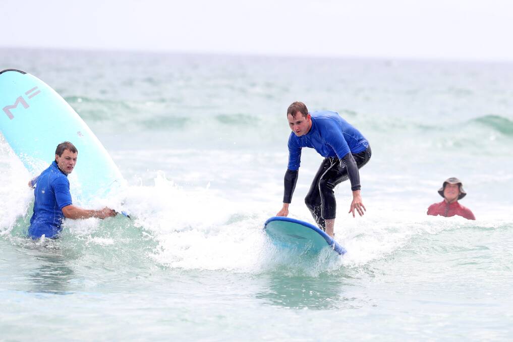 A couple of holidaymakers give surfing a go for the first time under the guidance of Crescent Head Learn to Surf School. Picture by Banjo 