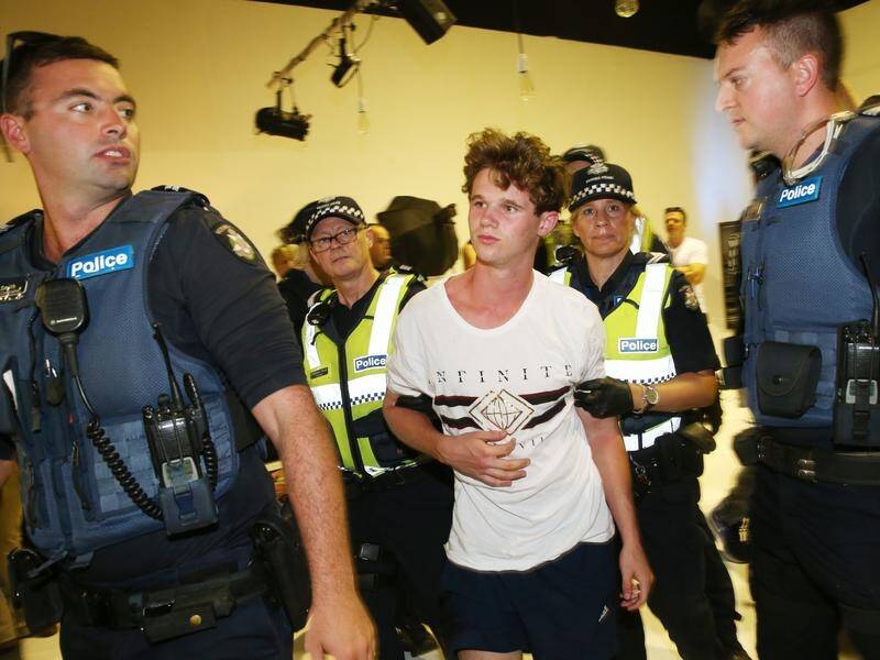 The teenager (centre) who smashed an egg on Senator Fraser Anning's head has admitted it was wrong.