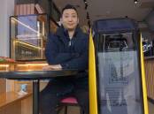 Jack Wang of the Hakko Bakery Cafe and the robot which delivers. Picture: Steve Evans