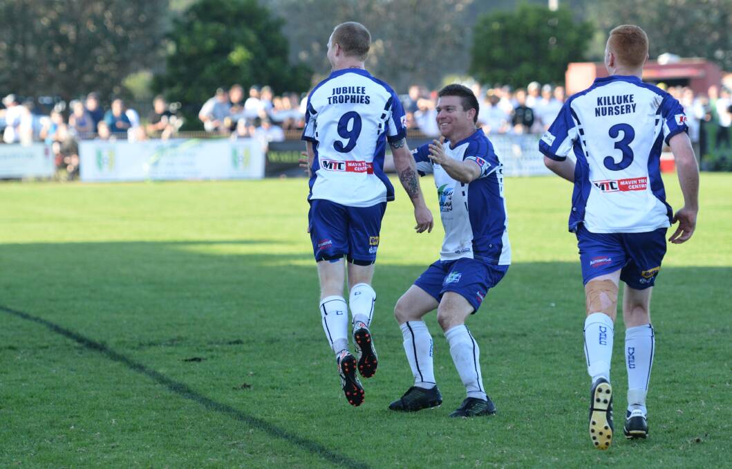 Andrew Potter (number nine) celebrates scoring the equaliser in the grand final on Saturday and leaps into the arms of Paul Thurlow.