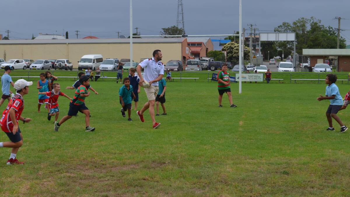 Former NRL player Beau Champion plays alongside Kempsey junior rugby league players.