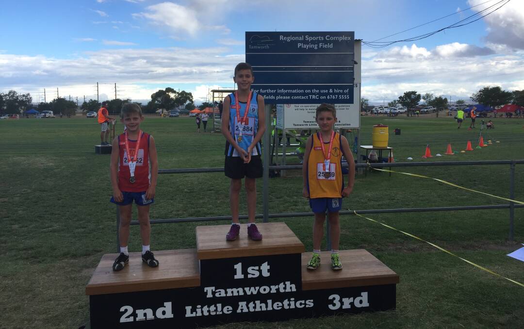 Champion: South West Rocks Little Athletics representative Spencer Plummer (centre) stands on the podium. Photo: Supplied.