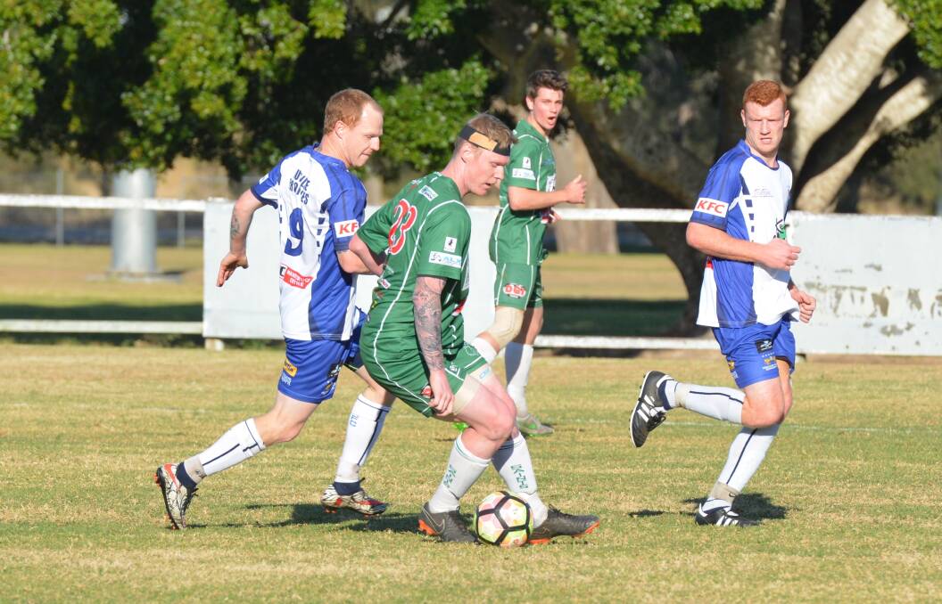 Footwork: Kempsey Saints' Troy Ward shields the ball from Macleay Valley Rangers striker Andrew Potter in a match last season. Photo: Penny Tamblyn.