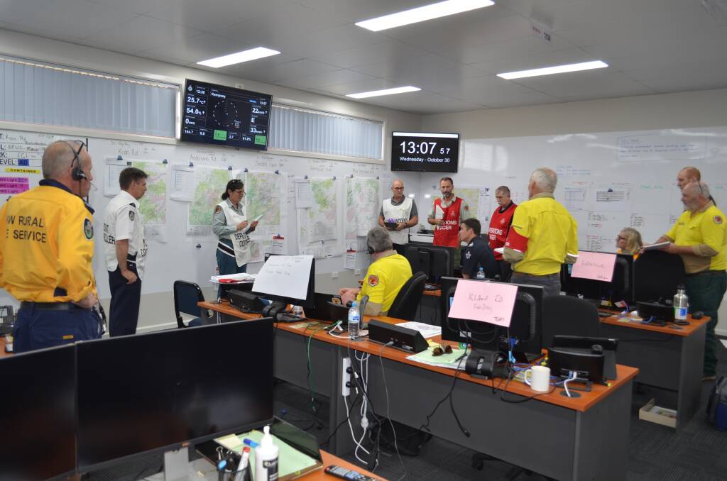 The NSW RFS Lower North Coast incident management team gathers for a meeting to update the situation on five current bushfires in the region. Photo: Callum McGregor