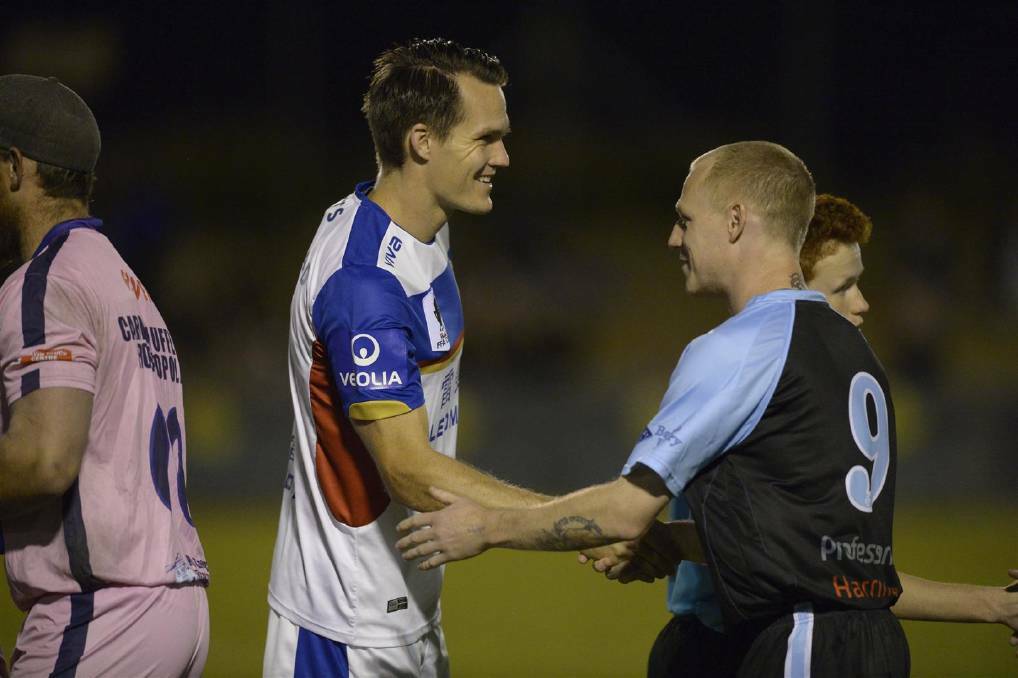 Professionalism: Andrew Potter shakes hands with Newcastle Jets captain Nigel Boogaard at last year's trial match in Port Macquarie. Photo: Matt Attard.